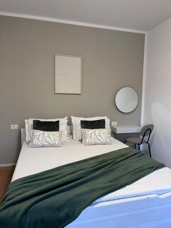 a bedroom with a large bed with a green blanket at Vila Happy House in Costinesti