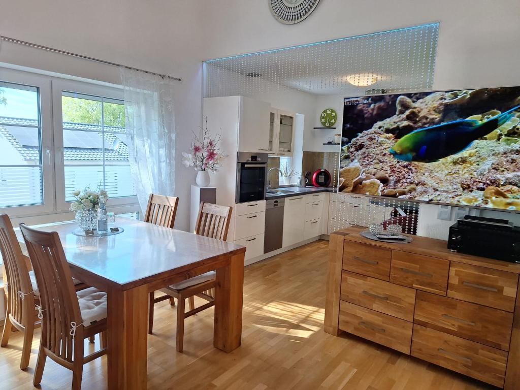 a kitchen with a dining room table and a tv at modern und gemütlich in Linden