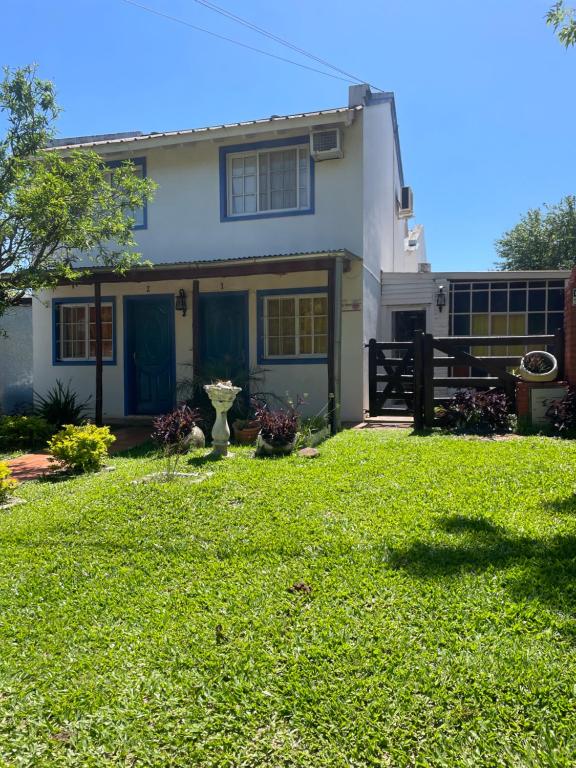 a white house with a yard with green grass at paldisfrute in Colón