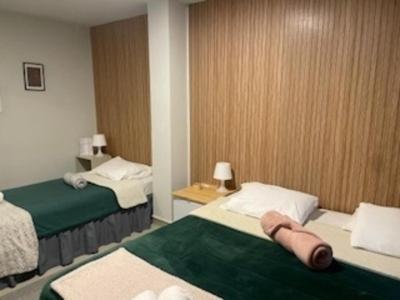 a hotel room with two beds with green and white at Liber Guest House in Braga