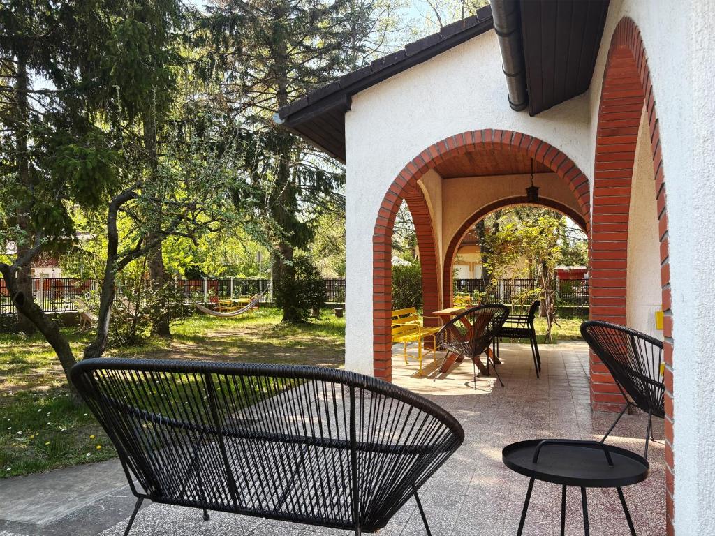 a patio with two black chairs and a table at Endretro Apartments in Siófok