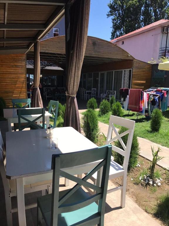a table and chairs in a yard with a fire truck at Femyli rooms in Shekhvetili