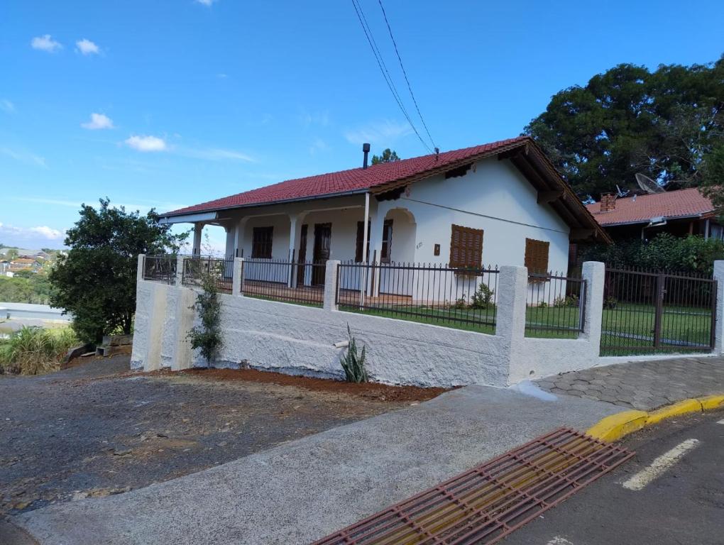 a white house with a fence in front of it at Hospedaria AlpenGlück in Treze Tílias
