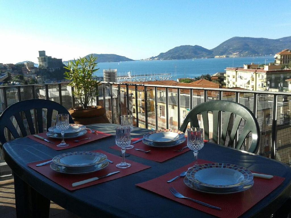 a table with plates and wine glasses on a balcony at La Terrazza sul Golfo in Lerici