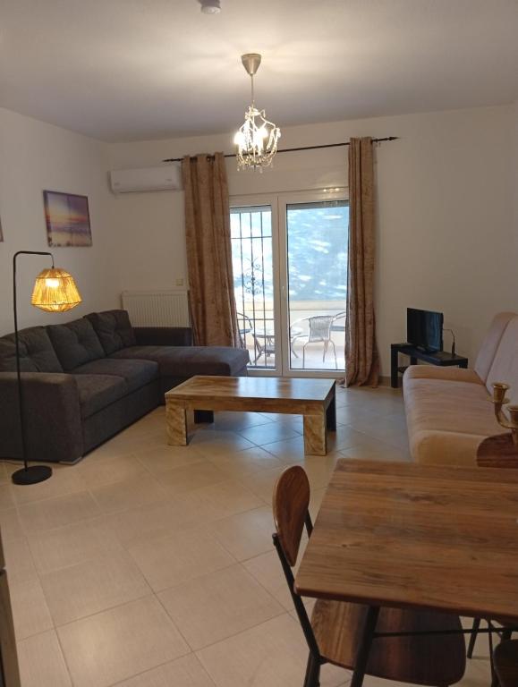 a living room with a couch and a table at Penelope apartment in Neoi Epivates