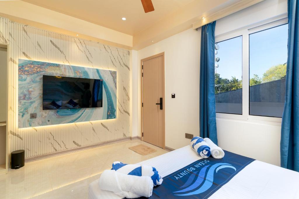 a bedroom with a large bed and a tv at Ocean Bounty in Ukulhas