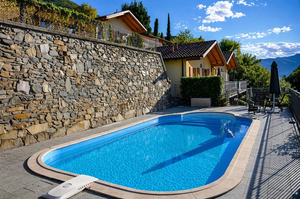 ein Schwimmbecken vor einer Steinmauer in der Unterkunft Case Bellissime in Tronzano Lago Maggiore