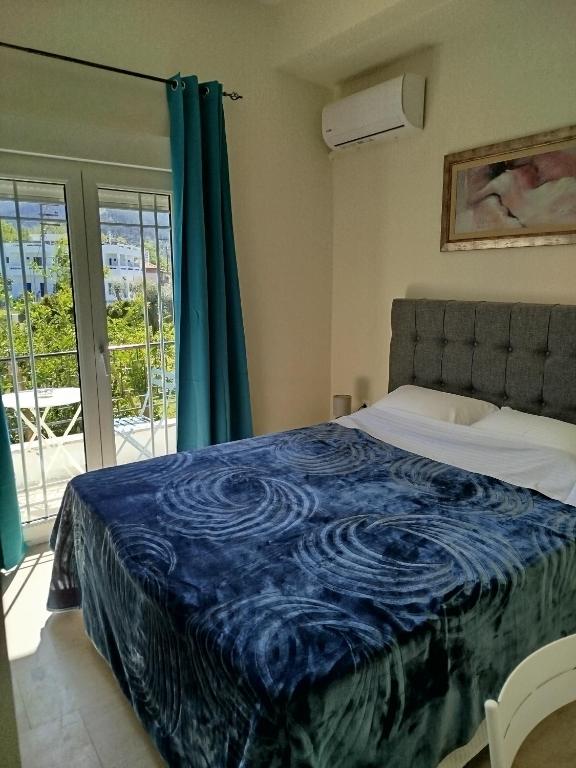 a bedroom with a bed with a blue blanket at Mirkashouse in Limenas