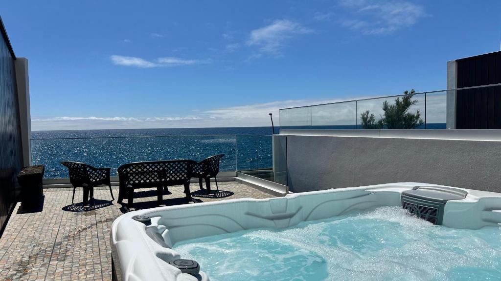 a hot tub on the balcony of a house with the ocean at South Shore 1 - Jacuzzi - HOST & CHILL in São Roque