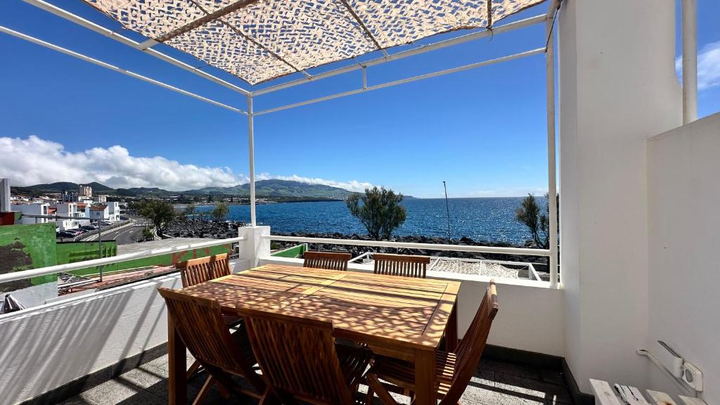 a table and chairs on a balcony with a view of the ocean at Ocean View Retreat 1 in São Roque