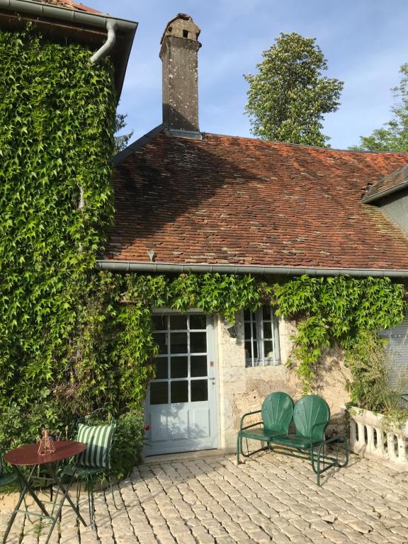 a house with a white door and two chairs at La Roseraie de Malpas in Quingey