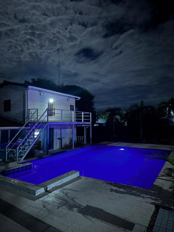 a house with a blue swimming pool at night at Casa con PISCINA PRIVADA Cielito in Flandes