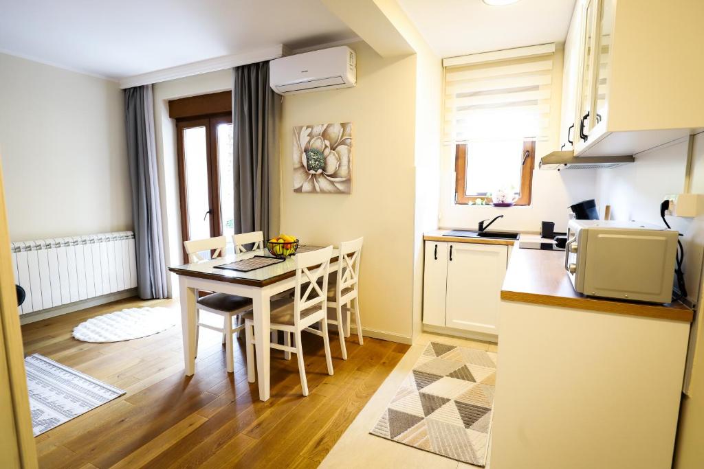 a kitchen and dining room with a table and chairs at BellaVita Apartman in Vrnjačka Banja