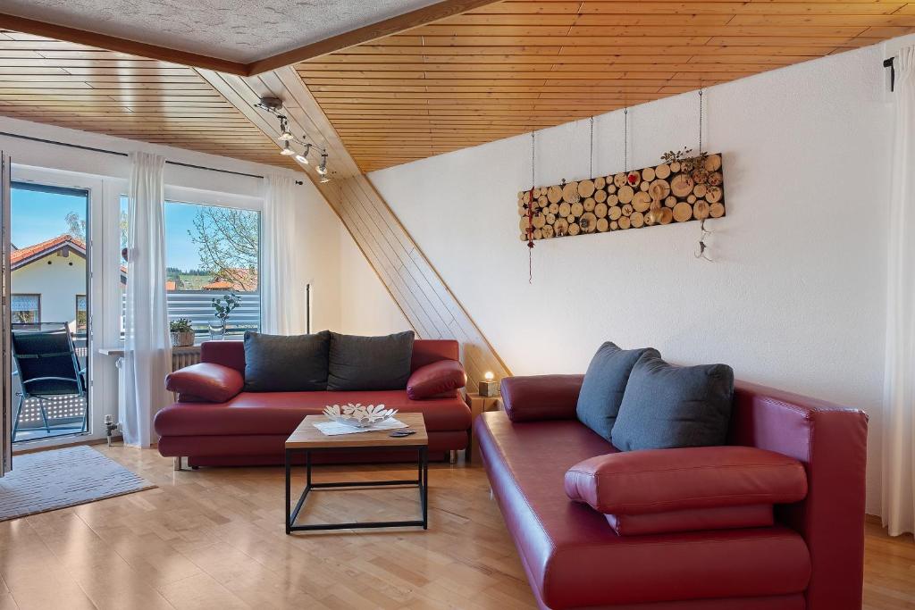 a living room with two red couches and a table at Ferienwohnung Brasil, 76 Qm in Schonach