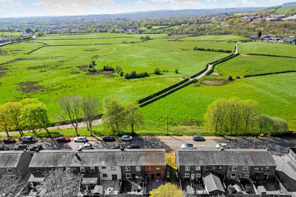 an aerial view of a green field and houses at Panoramic Sunset Views - Free Parking & Sleeps 5 in Heywood