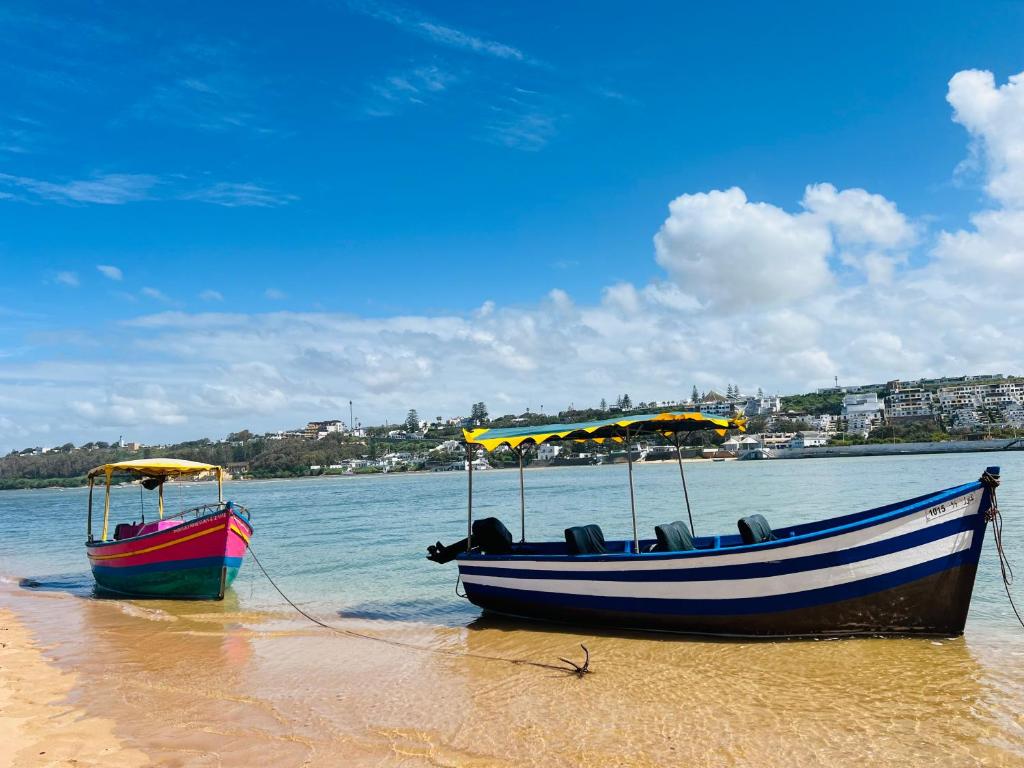 two boats sitting on the sand on a beach at Chez Yamaa in Oualidia