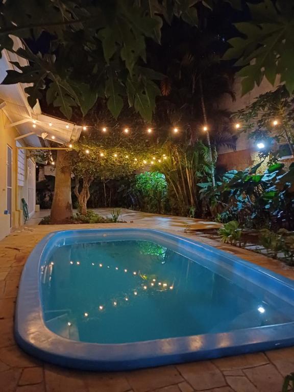 a swimming pool in a yard at night with lights at Villa Serena, próx do Aeroporto in Porto Alegre