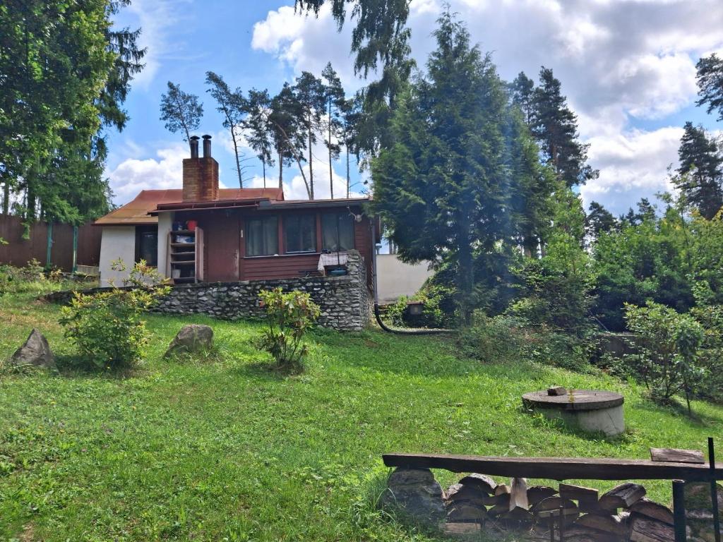 a house in the middle of a yard with a bench at Chaloupka na Kalovech in Sušice