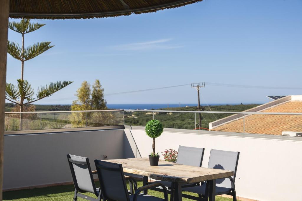 a table and chairs on a balcony with a view of the ocean at Royal Touch Suite in Loutra
