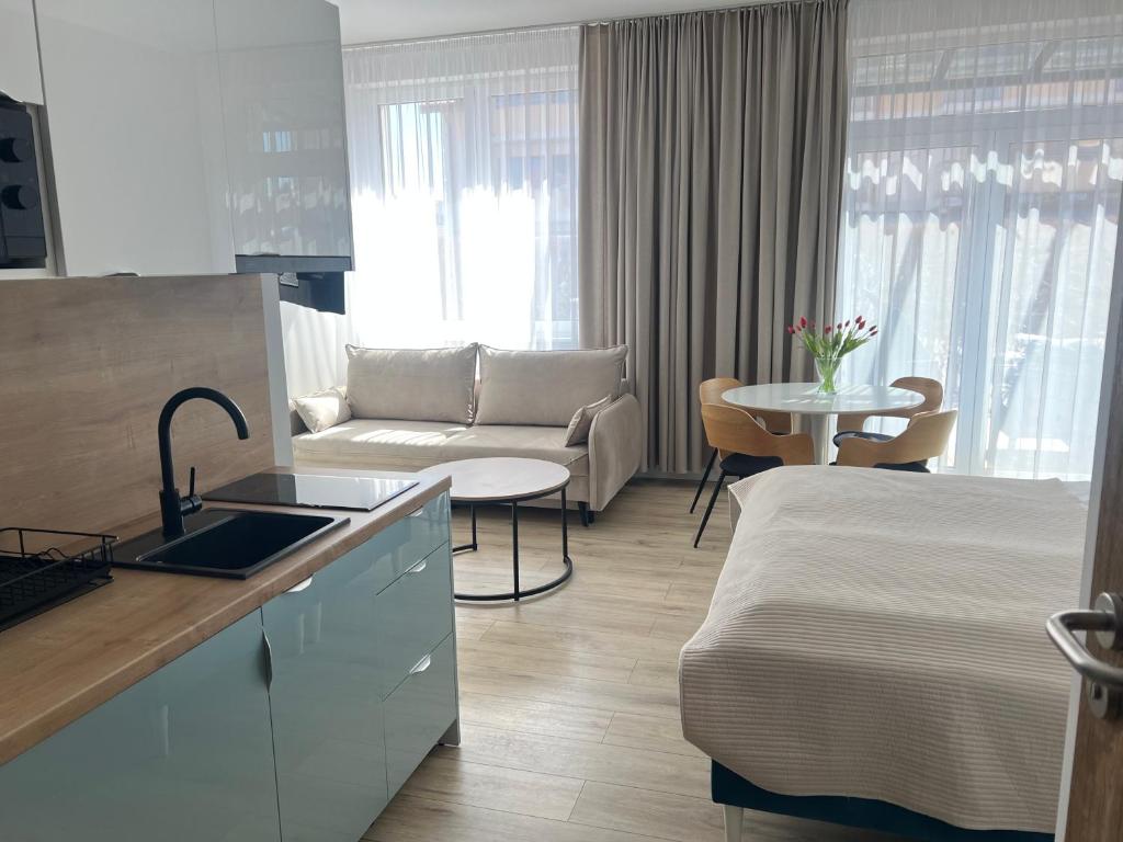 a hotel room with a bed and a kitchen and a living room at WILLA LAZUR in Łeba