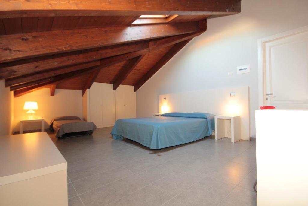 チヴィタノーヴァ・マルケにあるMansarde in Villaのベッドルーム1室(青いベッド1台付)