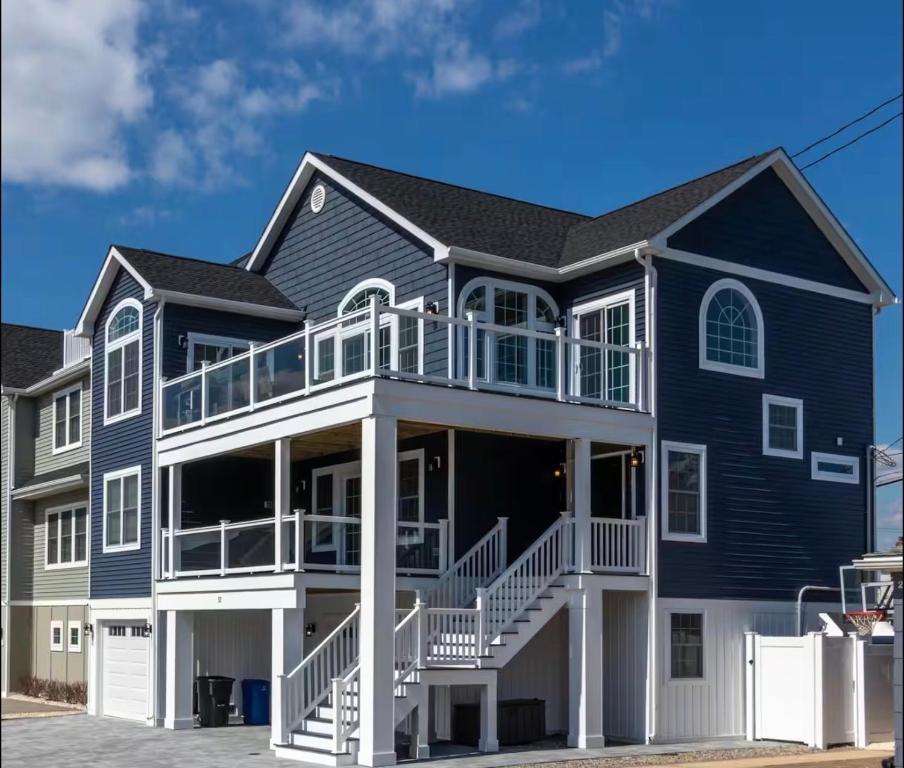 a large blue house with a large deck at The Royal Treat in Lavallette