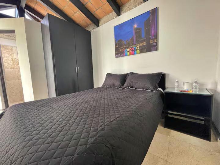 a bedroom with a bed and a painting on the wall at Comodo Estudio 8 in El Gallinero