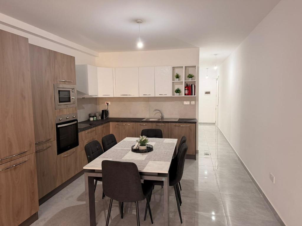 a kitchen with a table and chairs in a room at 11 Rose in Sannat