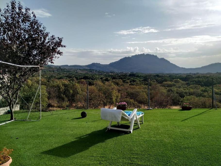 a white chair sitting on top of a green field at Chalet independiente con vistas in Bustarviejo