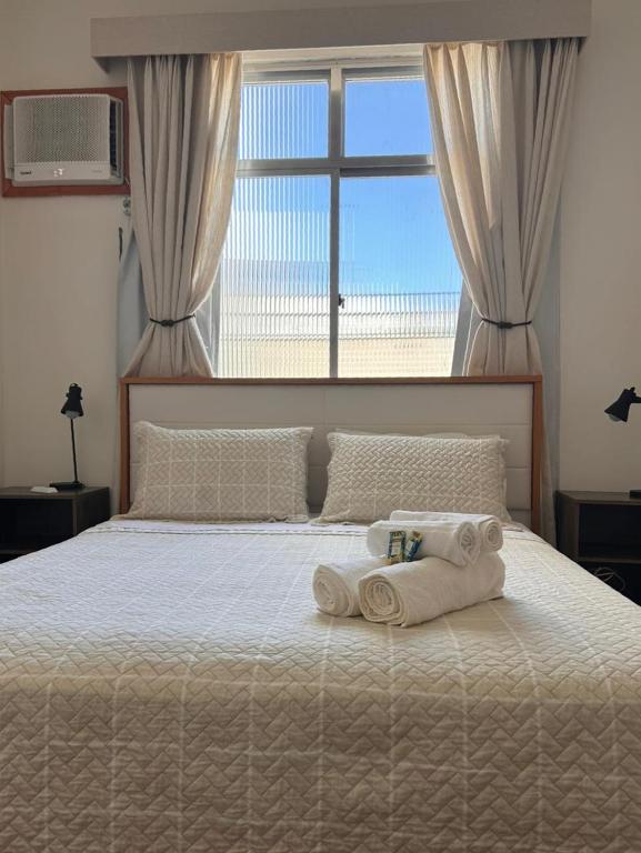 a bedroom with a bed with towels on it at Apê 5 min da praia de Copacabana, Pet Friendly in Rio de Janeiro