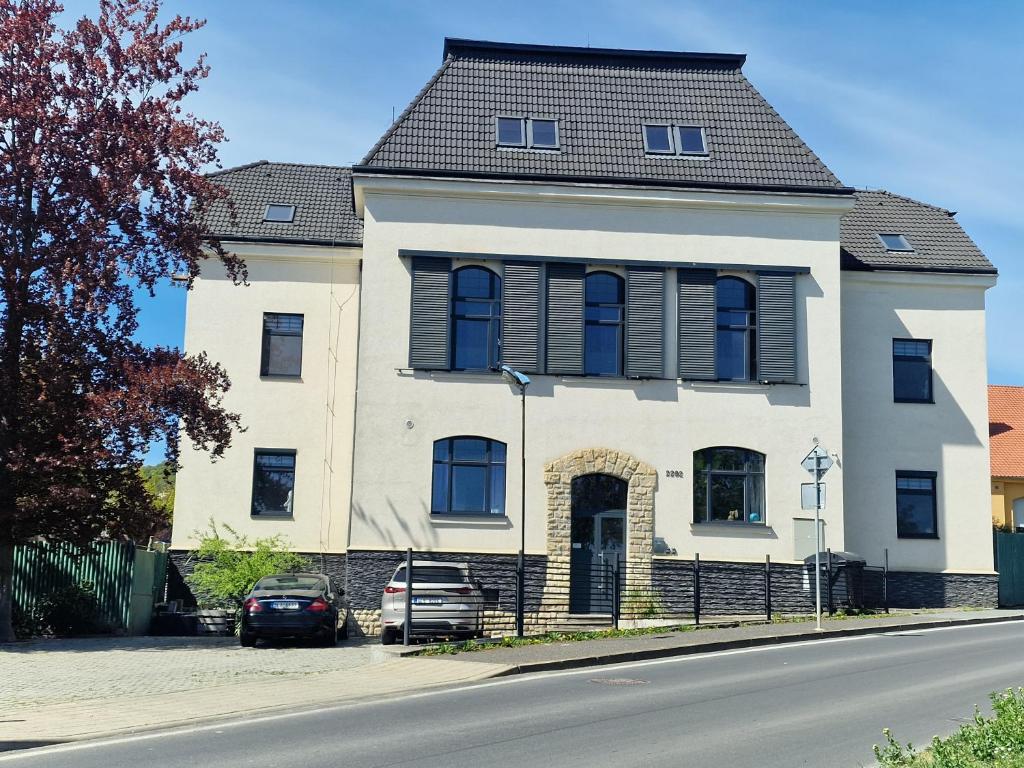 a large white house with a black roof at Apartmány Vila Singles in Litoměřice