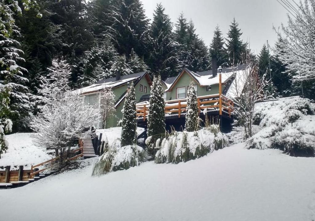 a house in the snow with snow covered trees at Hostería Verde Morada in Villa La Angostura
