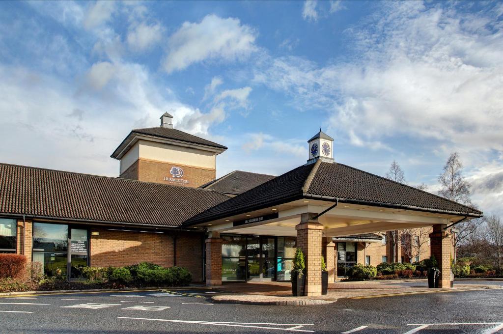 um edifício com uma torre de relógio em cima em DoubleTree by Hilton Edinburgh Airport em Ingliston