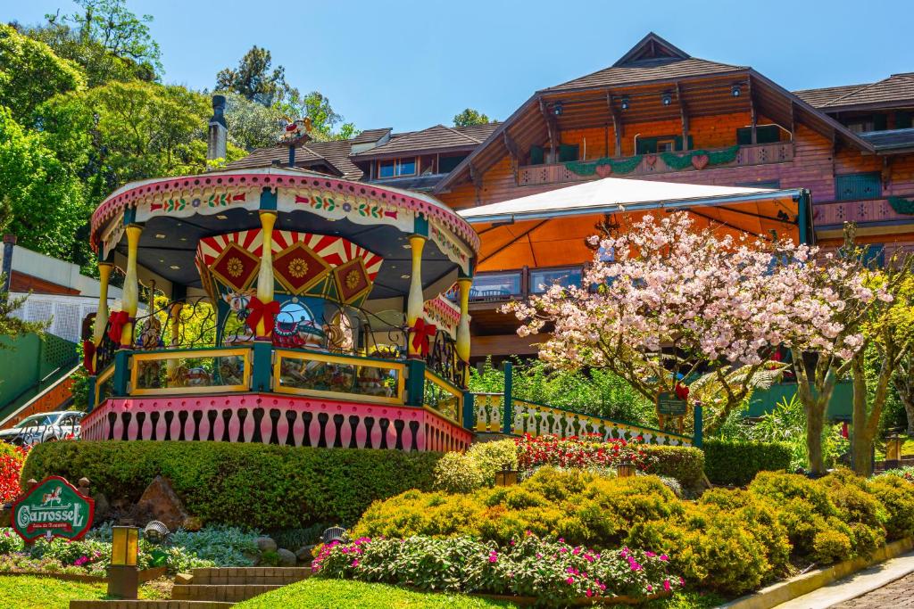 a garden in front of a house with a carousel at Casa da Montanha in Gramado