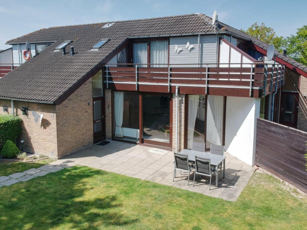 a house with a patio with two chairs at Rustpunt in Brouwershaven
