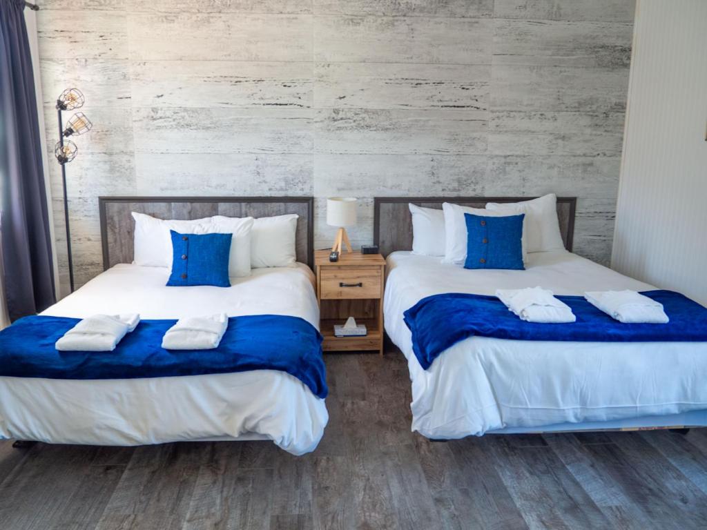 two beds sitting next to each other in a bedroom at Maison LeBreux - Motel in Petite-Vallée