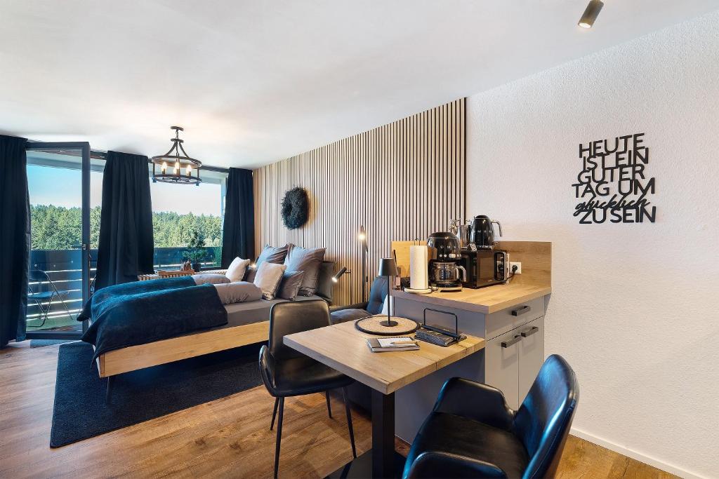 a living room with a bed and a table with chairs at Forest Elegance in Freudenstadt