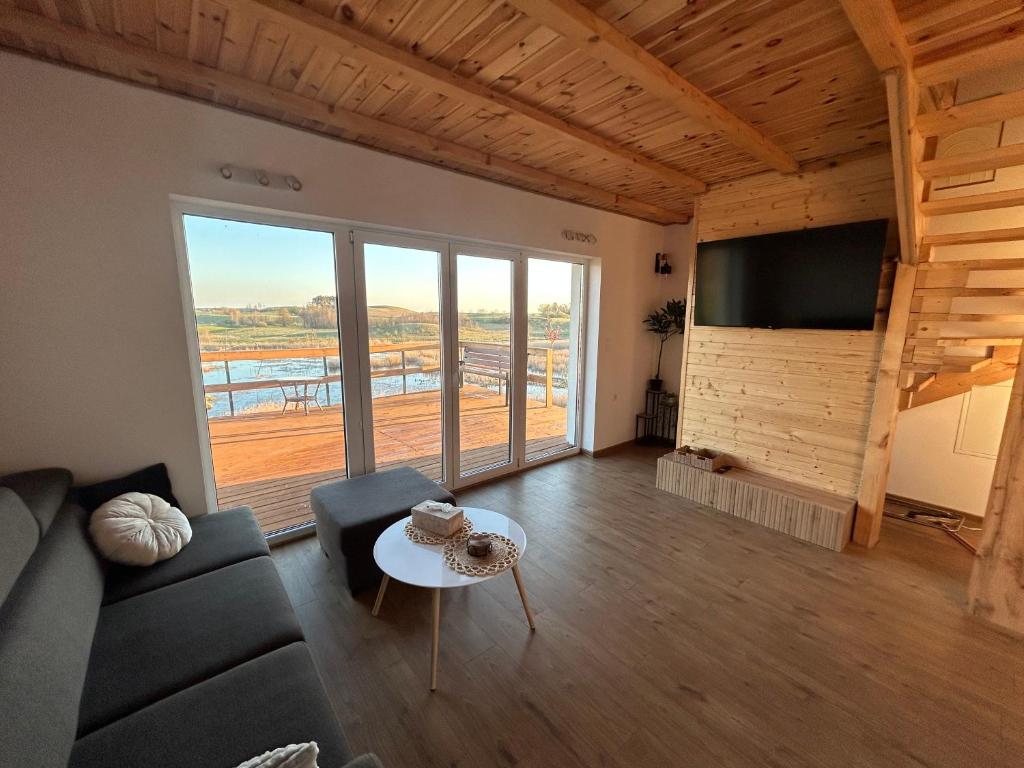 a living room with a couch and a tv and a table at Dom Pod Niebem in Świętajno