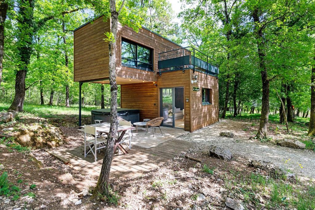 a house in the woods with a table and chairs at Cabane Spa-Truffiers-Proche Sarlat in Jayac