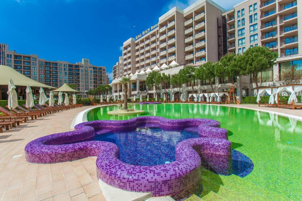 a large swimming pool with purpleoses in the middle at Hotel Barceló Royal Beach in Sunny Beach