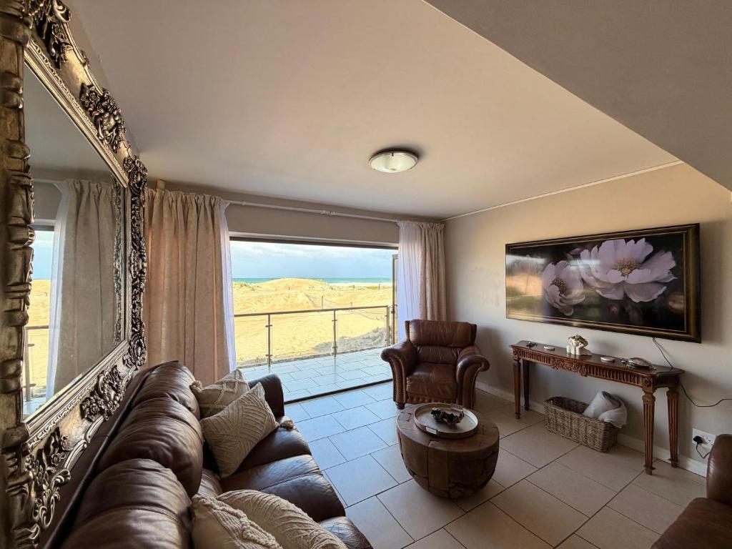 a living room with a couch and a large window at Klein paradys Jeffreys bay in Jeffreys Bay