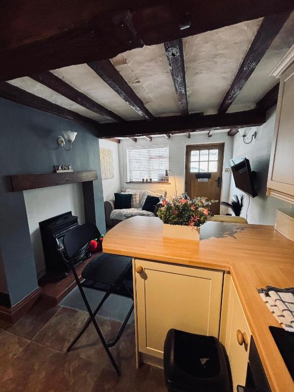 a kitchen with a counter and a living room at Agniti Cottage in Derby