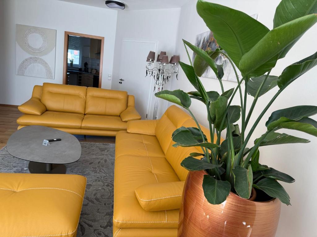 a living room with a yellow couch and a plant at Residence Loft in Friedrichshafen