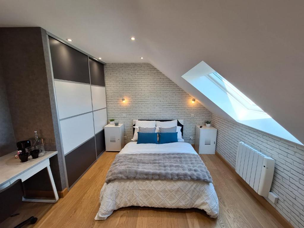 a bedroom with a large bed and a brick wall at Le Garage & Spa Silver in Gondreville