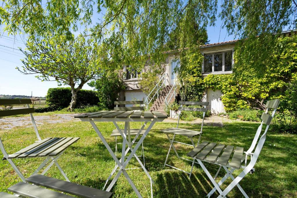 a picnic table and chairs in front of a house at Gîte De L'etrie in Mauves-sur-Loire