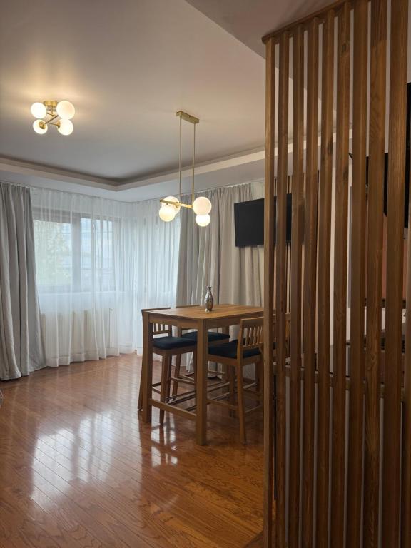 a dining room with a table and chairs and a chandelier at Cozy Corner Apartments in Bistriţa