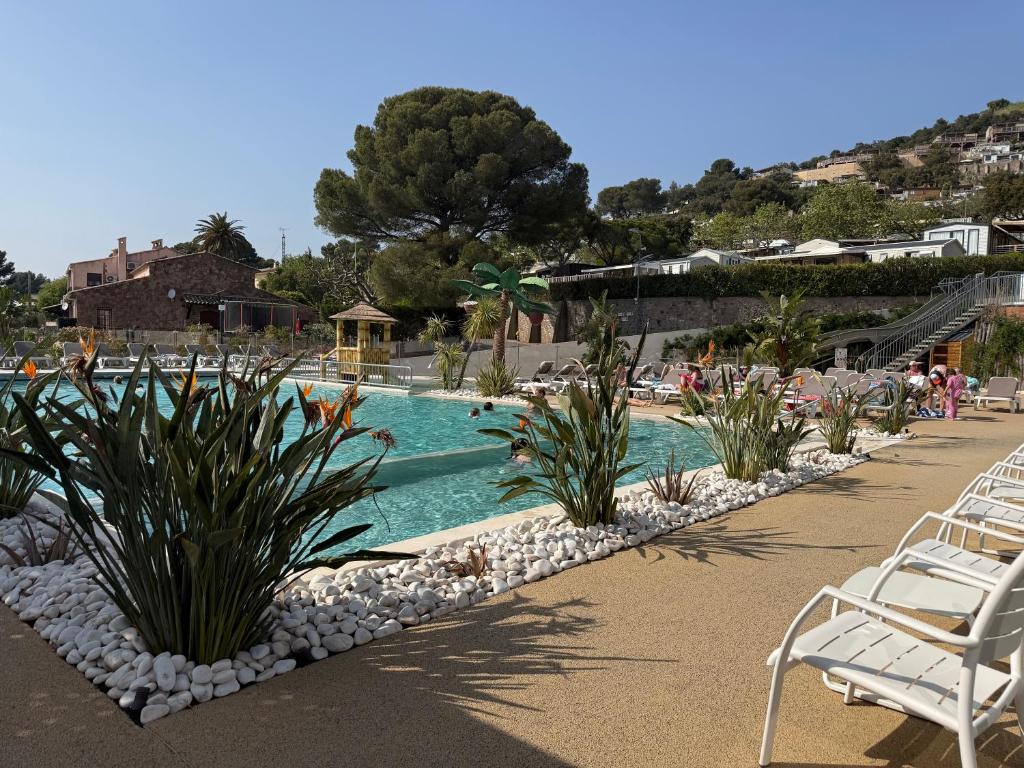 ein Schwimmbad mit Liegestühlen und Pflanzen in einem Ferienresort in der Unterkunft Ethan in Saint-Raphaël