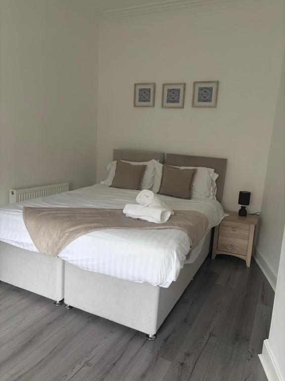 a bedroom with a large bed with white sheets at Union Street Apartment in Hawick