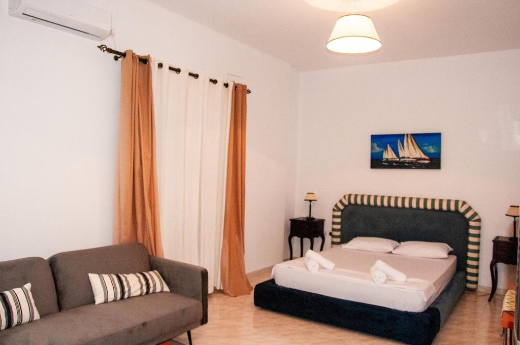 a living room with a bed and a couch at Arcadia Coastal Studio by ΜΡS in Xiropigado