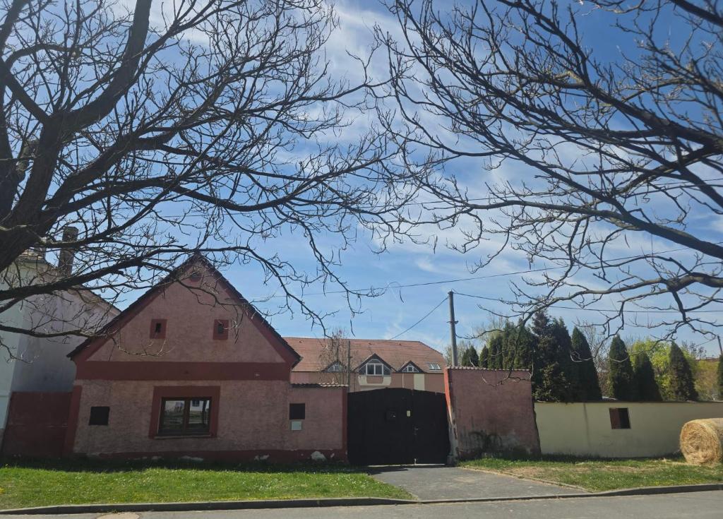 an old red brick house with a tree at Apartmán na statku NH Stables in Nýřany
